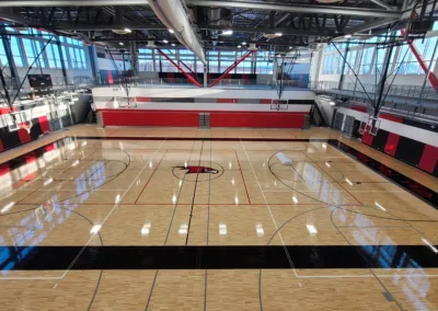 An indoor basketball court with red and black stripes.